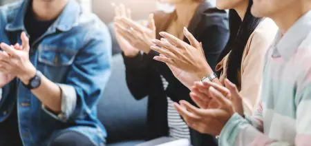 close-up of four pairs of clapping hands
